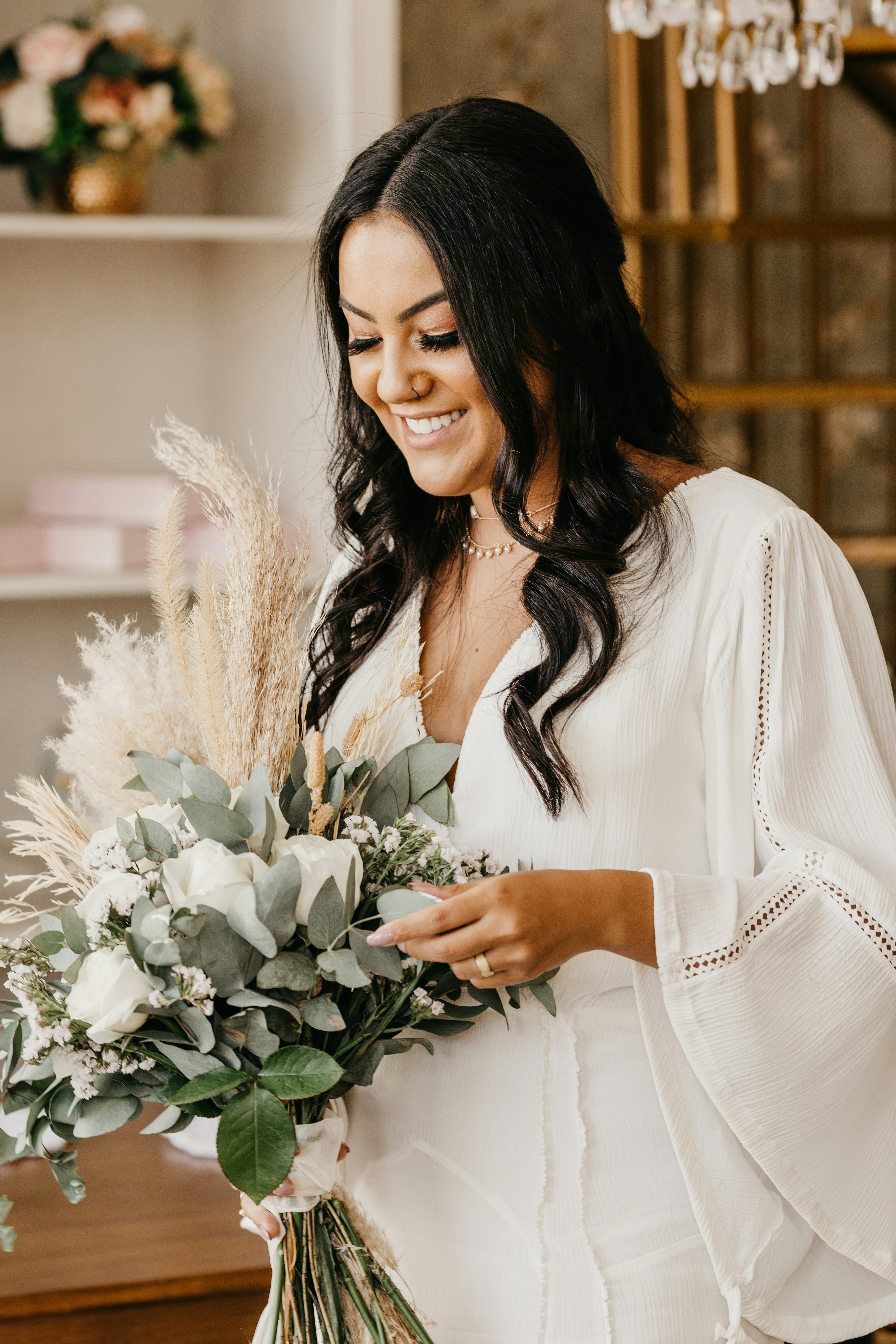 woman in white long sleeve shirt holding white flowers